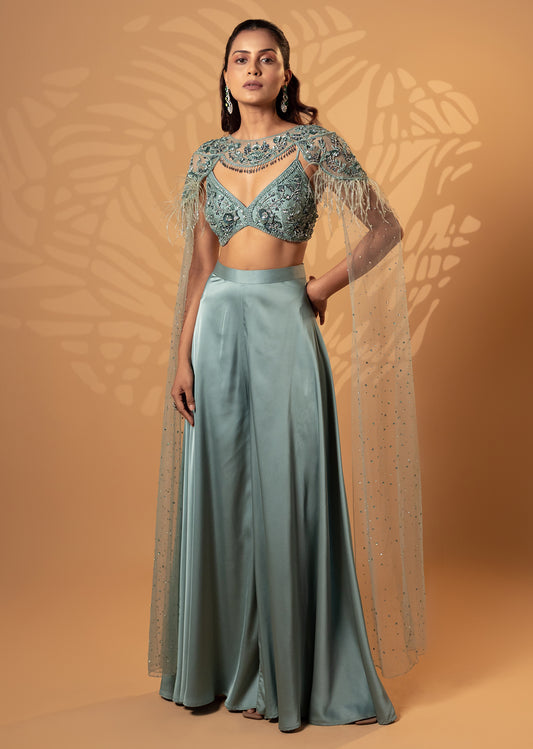 Woman wearing a teal traditional outfit with a textured background