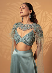 Woman wearing a light blue embroidered blouse with a matching skirt against a beige background